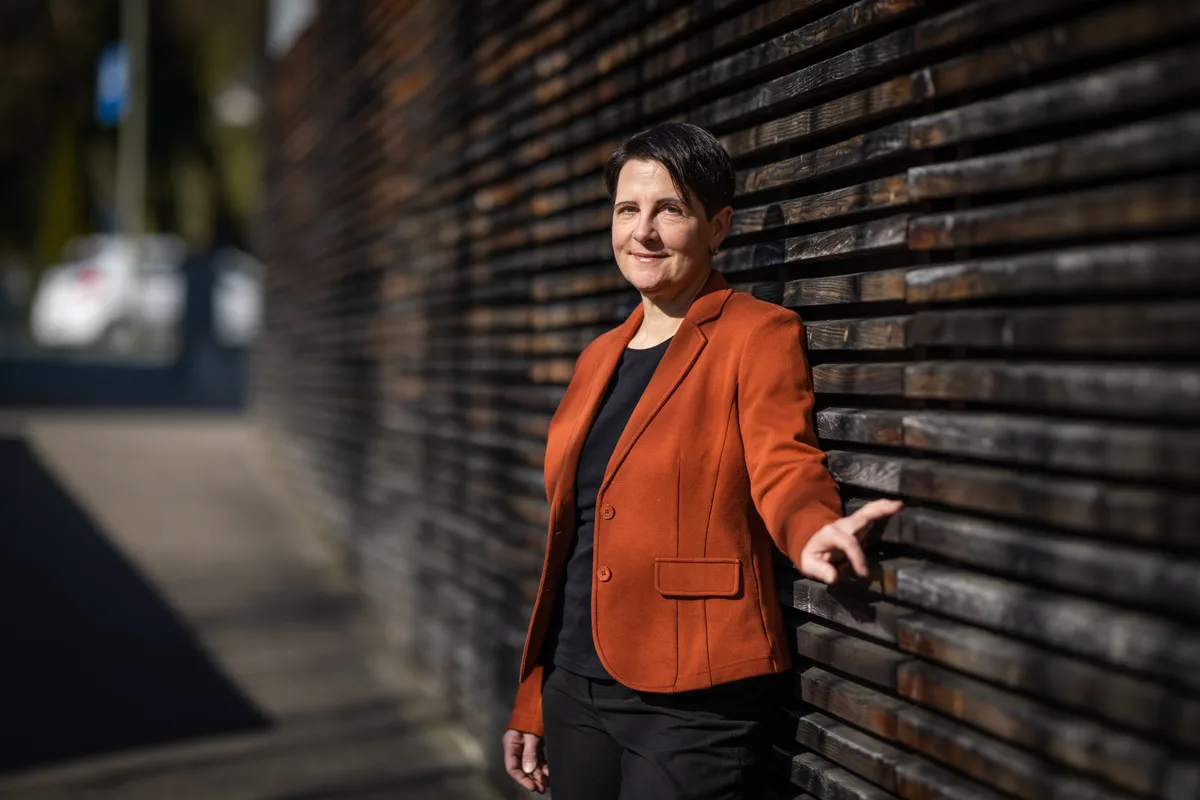 Yvonne Bürgin steht an einer Holzwand.